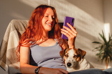 Teenage girl or young woman looks at phone at home