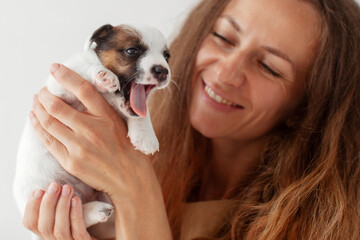 Smiling Woman looking at yawning Puppy Dog