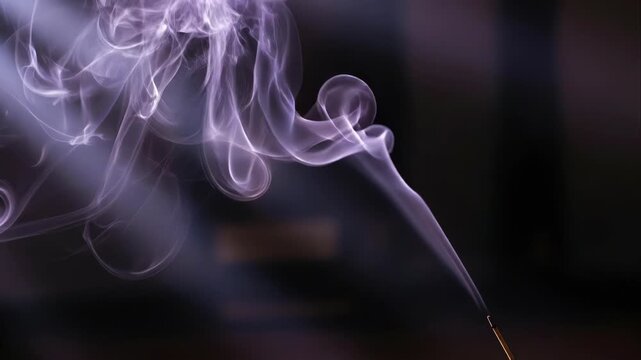 Purple smoke swirls rising from a burning incense stick in a dark background