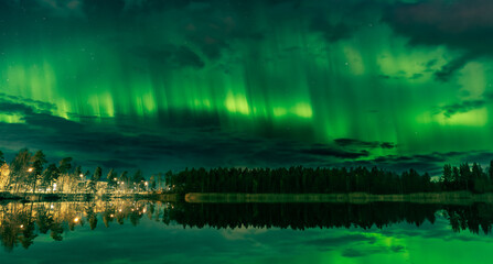 Green Aurora over Finnish Lake with Autumn Reflection