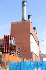 The Con Edison East River Generating Station power plant stands against a clear blue sky in New York City, Manhattan.