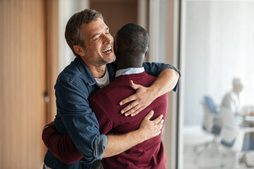 Joyful Hug Between Friends in Office, Warm Greeting and Celebration, Positive Moment Shared Connection Today
