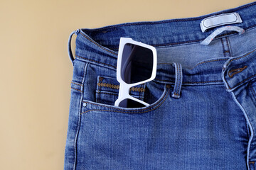 Sunglasses in blue jeans pocket,fashionable jeans.