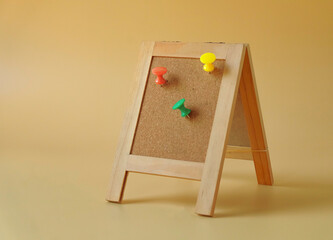 Color push pin on wood board on color background.