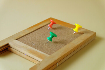 Color push pin on wood board on color background.