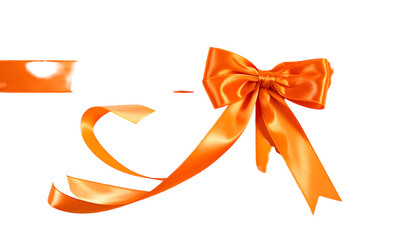 A vibrant orange satin ribbon bow with trailing tails and a gift tag against a black background