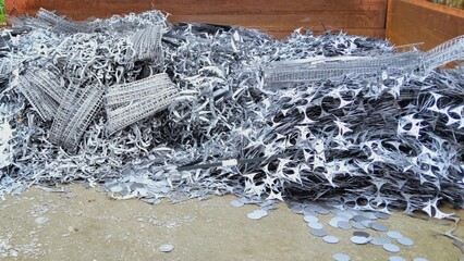 Heap of scrap metal pieces and perforated sheets ready for recycling in industrial yard.
