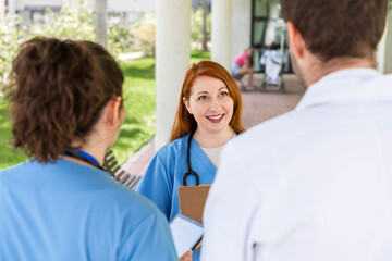 Obraz premium Medical team on hospital grounds smiling and engaging in discussion, collaborating and communicating in a professional healthcare environment during daily operations