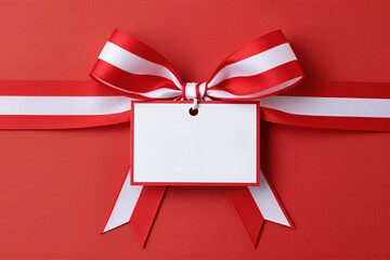 Red and white ribbon with gift tag on red background