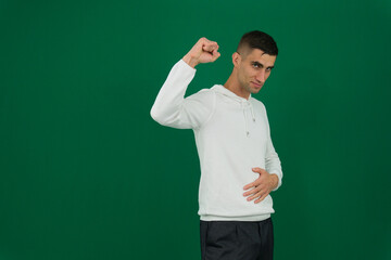 Young man of African American ethnicity wear green hoodie casual clothes hold hand at forehead look far away distance isolated on plain pastel light beige background studio portrait. Lifestyle.