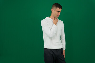 A man has a sore throat and neck due to a cold. man holds hand to throat. He experiences discomfort when swallowing. The concept of viral diseases. A man holding his hand in his throat has pain