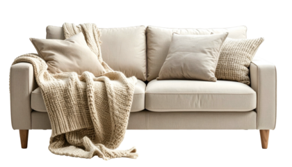 A neutral-toned sofa with pillows and a knitted blanket. A cozy, inviting living space