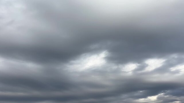 Thick gray cloud layers crossing the sky at a slow pace, overcast weather atmosphere with low light and heavy cloud cover, natural background for forecasts, transitions, and copy space.