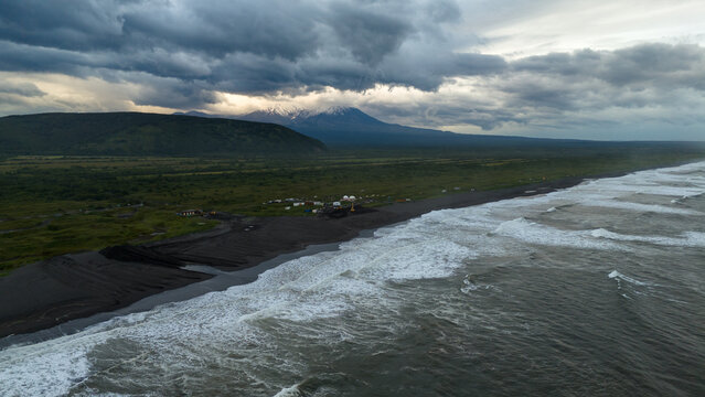 Coastal landscape aerial view with waves crashing onto black sand beach - Powered by Adobe