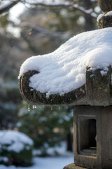 Macro view of a snow-dusted Japanese stone lantern, captured in soft winter light for a peaceful mood.