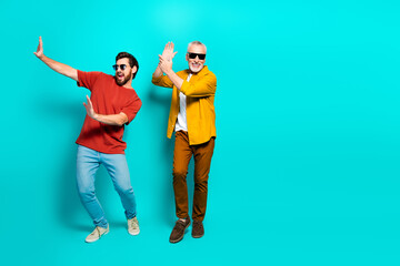 Fototapeta premium Two friends dance in a bright teal background showing joy friendship and connection