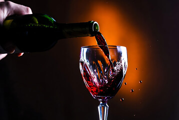 Red Wine Being Poured into Crystal Glass, Dark Background
