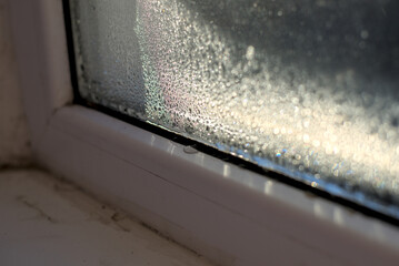 Drops of humidity on the window with morning sun