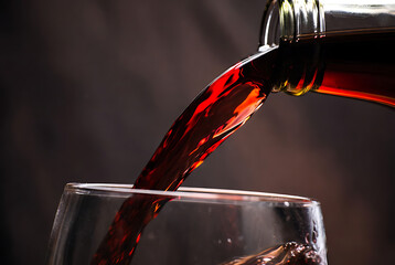 Red Wine Being Poured into Crystal Glass, Dark Background