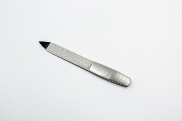 Metal nail file with textured abrasive surface closeup on white.