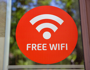 Free wifi sign sticker on glass window closeup.