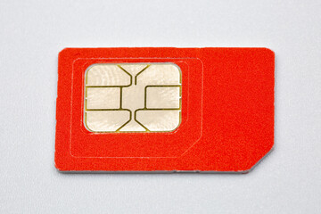 Orange SIM card with golden chip on white background closeup.