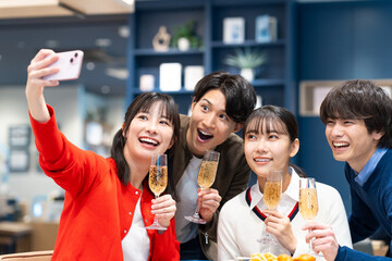 パーティーで写真を撮る若い男女