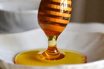 Golden Honey Dripping from Wooden Honey Dipper