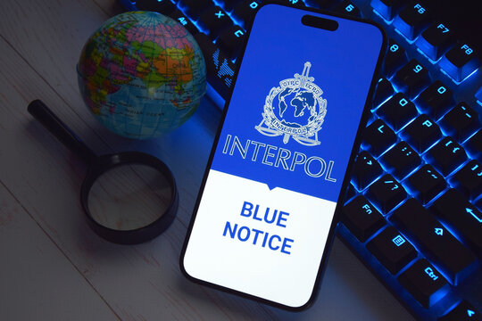 The smartphone with Interpol logo displayed on screen. International Criminal Police Organization or Interpol.