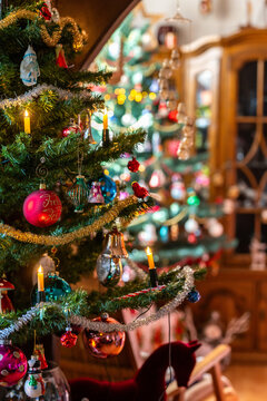 Ein dekorierter Weihnachtsbaum mit einem zweiten im Hintergrund