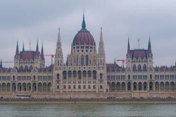Fototapeta premium View of the Hungarian Parliament, riverside Danube, winter sunset sky, blue hour, romantic vibes, Budapest, Hungary.