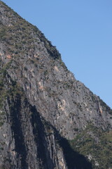 Panoramic autumn mountain landscape featuring a high peak view over a misty forest valley with green trees and a lake under a cloudy sky in Laos