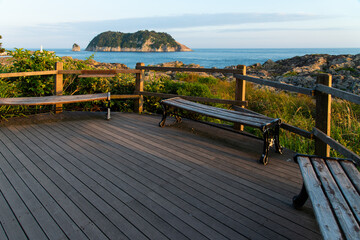 wooden observatory with bench against sea and an island in Jeju Island, South Korea