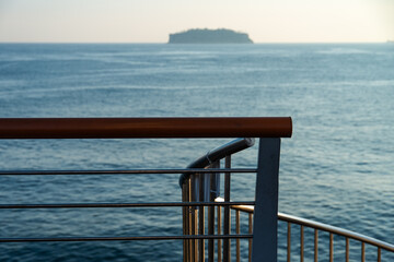 idyllic seascape with bridge railing and an island 