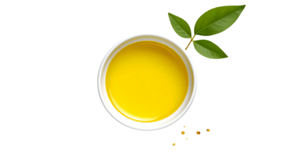 Overhead shot of a white bowl filled with yellow liquid, with a leafy branch