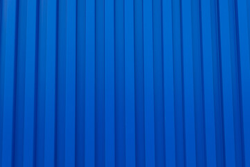 Blue Corrugated Metal Sheet Texture Background,Close-up of a vibrant blue corrugated metal wall with vertical ridges. This high-resolution texture features a repetitive geometric pattern, ideal for