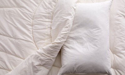 Pillow and bedding arrangement in a serene bedroom setting with white comforter and soft pillows