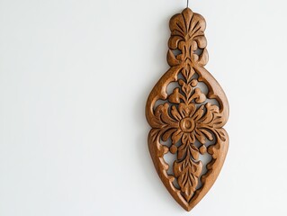 A wooden wall decoration hangs alone on a white background. It has carvings and details in a modern, simple style, like boho or Scandinavian design.
