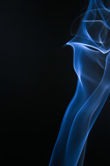 Abstract blue smoke gracefully rising against a black backdrop, creating a captivating visual effect. The smoke has a delicate texture and elegant curves, adding a touch of mystery to the scene.
