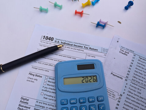 2026 tax filing with IRS Form 1040 and blue calculator