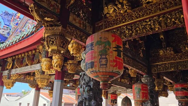 Traditional Chinese temple with ornate roof decorations and architecture in Malaysia. Historic Khoo Kongsi clan house with intricate carvings, red pillars and courtyard. Cultural heritage landmark in 