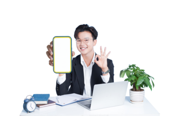Young Professional at Desk with Mobile: A cheerful young professional sits at a desk, showcasing a blank mobile screen, indicating a perfect technological solution or app interface.