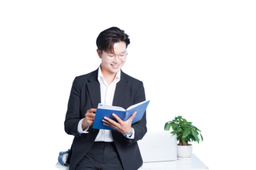 Focused and Knowledgeable: A professional, exuding confidence, immerses himself in a book. This shot captures his focus, glasses, and smart attire, complemented by the plant and notebook
