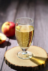 Refreshing Glass of Sparkling Apple Cider on Rustic Wooden Coaster