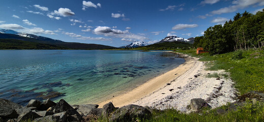 White Sand Beach And Snowy Mountains At The Fjord Cost Of Lofoten Islands In Norway