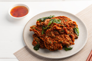 Deep fried fish patty or Thai Fish cake with crispy basil (Tod mun pla) in a plate.