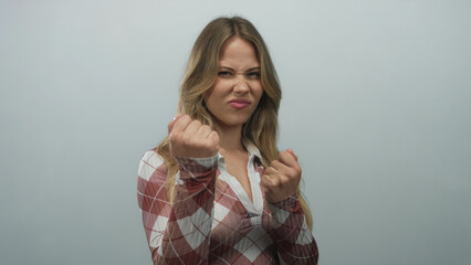 Woman intensely and dramatically raises clenched fists in photo studio; defiance determination...