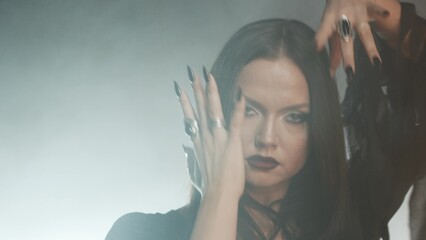 Femme fatale in gothic black dress with corset, elegant dark interior portrait.