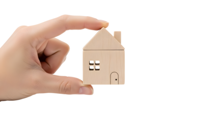 A wooden house miniature held delicately between fingers, highlighting the concept of home ownership, real estate, and property