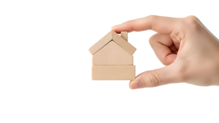 A hand delicately holding a small wooden house. The scene conveys concepts of homeownership, construction and real estate